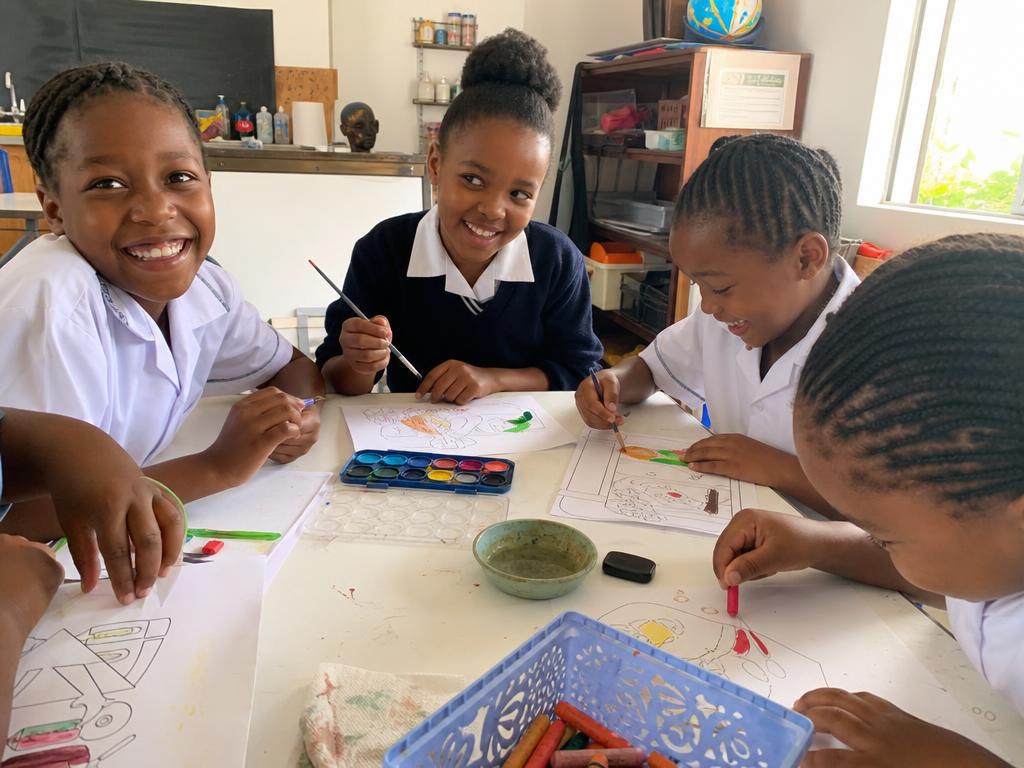 Girls doing arts and crafts at small tables